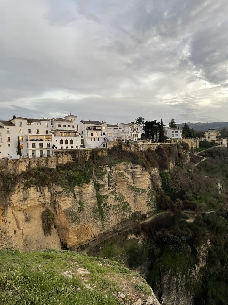 Ultimate day trip to Ronda. Pueblo blanco of Ronda on a cloudy evening, standing on the edge of a cliff