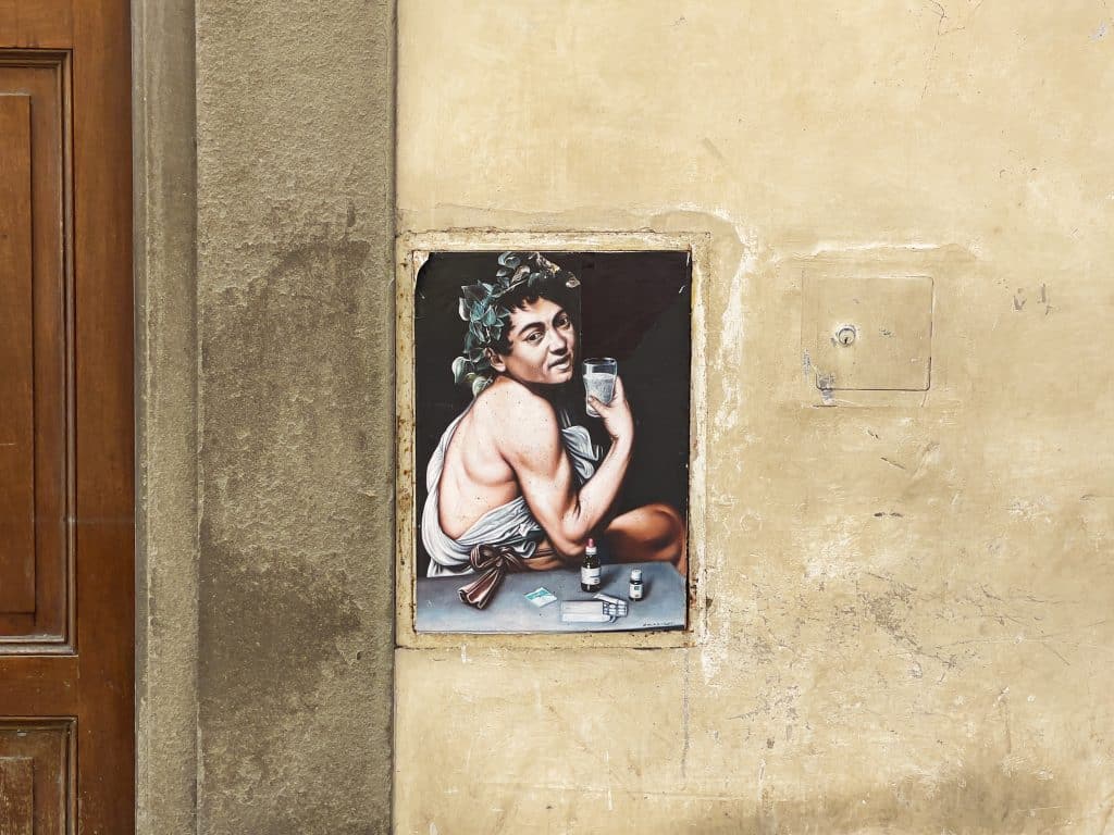 21 Photos to Inspire You to Visit Florence, Italy. Bacchus by Caravaggio Florence Street Art edition. Street artist is Maurizio Rapiti