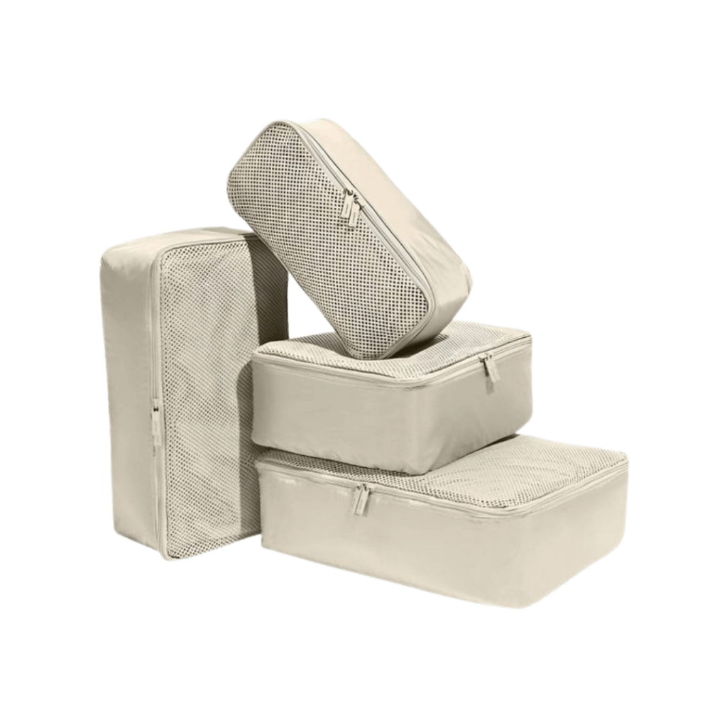 Four beige packing cubes of varying sizes are stacked together. Three cubes have mesh tops with zippers, and one cube, standing upright, has a solid beige top with a zipper. The background is white.