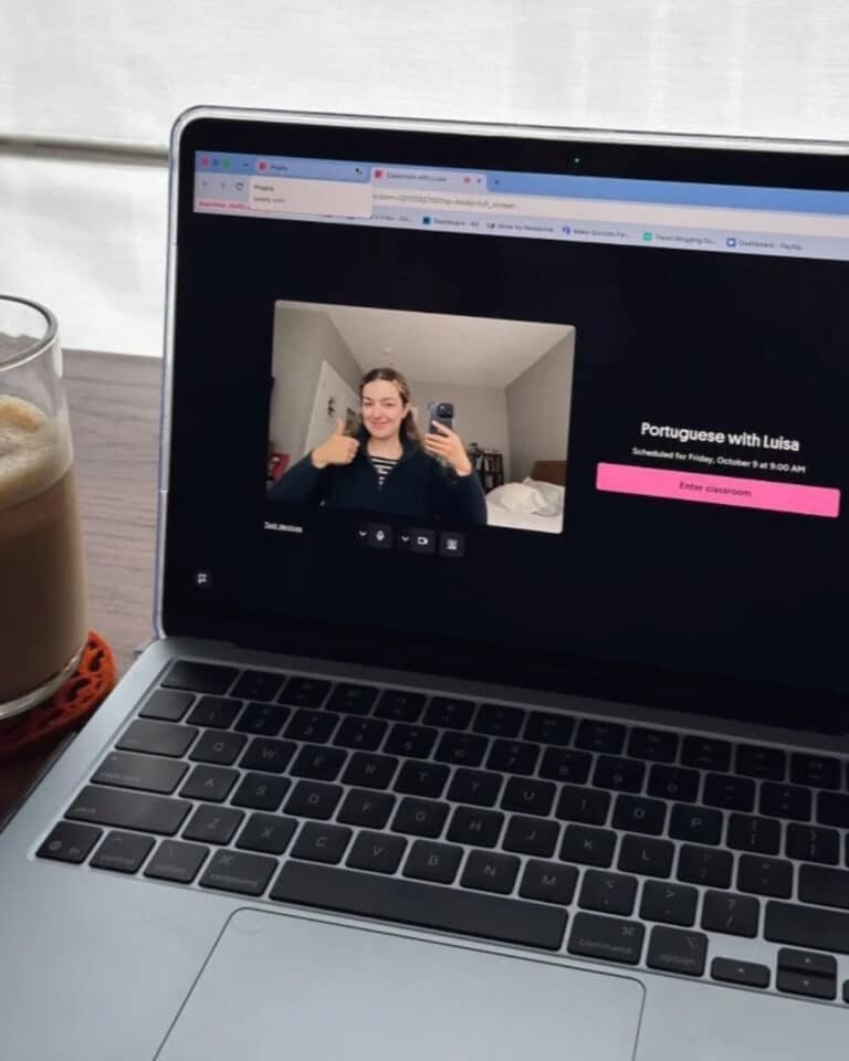 A laptop screen displays an online Preply classroom interface with a video preview of a woman giving a thumbs up and a button to enter the “Portuguese with Luisa” session.